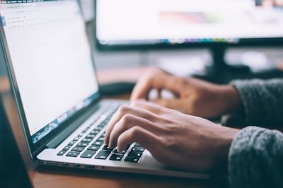 Foto pelanggan dengan pulpen di tangan menulis di laptop side
